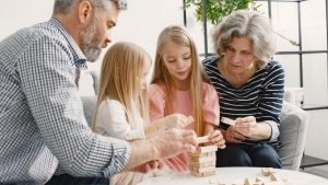 A family enjoying time together playing a block stacking game in their living room.